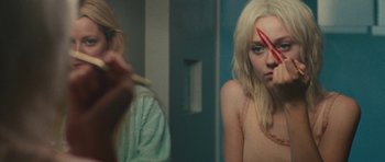 Movie still from “The Runaways” (2010), directed by Floria Sigismondi – A woman with a knife in front of a mirror; Close Up shot, High angle