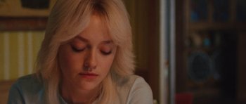 Movie still from “The Runaways” (2010), directed by Floria Sigismondi – A person sitting down with her eyes closed; Close Up shot, Over the shoulder angle