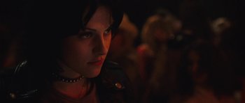 Movie still from “The Runaways” (2010), directed by Floria Sigismondi – A person wearing a necklace in the dark; Close Up shot, Over the shoulder angle