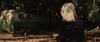 Movie still from “The Runaways” (2010), directed by Floria Sigismondi – A woman standing in front of a chain link fence; Medium shot, Over the shoulder angle
