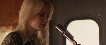 Movie still from “The Runaways” (2010), directed by Floria Sigismondi – A blonde woman is holding a microphone up to her face; Close Up shot, Low angle