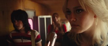 Movie still from “The Runaways” (2010), directed by Floria Sigismondi – A woman holding a microphone in front of another woman; Close Up shot, Over the shoulder angle