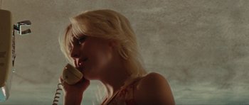 Movie still from “The Runaways” (2010), directed by Floria Sigismondi – A woman is talking on a phone and smiling; Close Up shot, Low angle