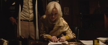 Movie still from “The Runaways” (2010), directed by Floria Sigismondi – A woman sitting at a table writing on a piece of paper; Medium shot, Over the shoulder angle