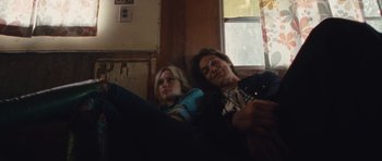 Movie still from “The Runaways” (2010), directed by Floria Sigismondi – Two people laying on a couch next to each other; Medium shot, Low angle