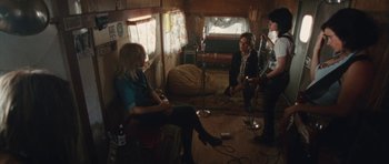 Movie still from “The Runaways” (2010), directed by Floria Sigismondi – A group of people sitting around in a room; Wide shot, High angle
