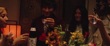 Movie still from “The Runaways” (2010), directed by Floria Sigismondi – A man and a woman sitting in front of a table; Medium shot, Over the shoulder angle