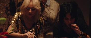 Movie still from “The Runaways” (2010), directed by Floria Sigismondi – A group of people sitting at a table with drinks; Close Up shot, High angle