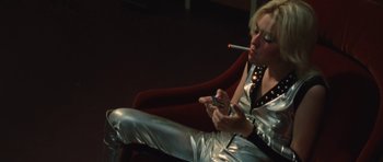 Movie still from “The Runaways” (2010), directed by Floria Sigismondi – A woman smoking a cigarette while holding a cell phone; Medium shot, Low angle