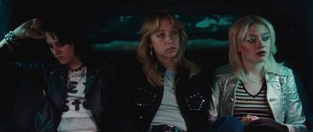 Movie still from “The Runaways” (2010), directed by Floria Sigismondi – A woman sitting in the back seat of a car; Medium shot, Low angle