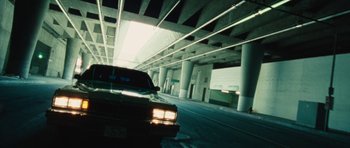 Movie still from “The Runaways” (2010), directed by Floria Sigismondi – A car driving down a street under an underpass; Wide shot, Low angle