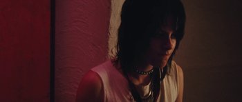 Movie still from “The Runaways” (2010), directed by Floria Sigismondi – A woman wearing a white tank top and a black necklace; Close Up shot, Low angle
