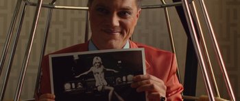 Movie still from “The Runaways” (2010), directed by Floria Sigismondi – A man in a red jacket holding a picture of a woman; Close Up shot, High angle