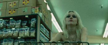 Movie still from “The Runaways” (2010), directed by Floria Sigismondi – A woman in a grocery store looking at the camera; Close Up shot, Low angle
