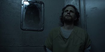 Movie still from “House of Cards” (2013), created by Beau Willimon – A man in a jail cell looking at himself in the mirror; Medium shot, Over the shoulder angle