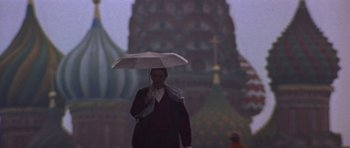 Movie still from “The Russia House” (1990), directed by Fred Schepisi – A person with an umbrella walking down a street; Wide shot, Low angle