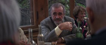Movie still from “The Russia House” (1990), directed by Fred Schepisi – An older man sitting at a table with a glass of wine; Medium shot, Over the shoulder angle