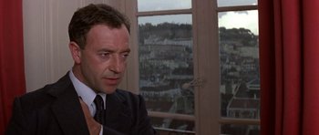 Movie still from “The Russia House” (1990), directed by Fred Schepisi – A person wearing a suit and tie; Close Up shot, Over the shoulder angle