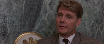Movie still from “The Russia House” (1990), directed by Fred Schepisi – A person wearing a suit and tie; Close Up shot, Over the shoulder angle