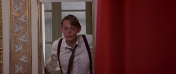 Movie still from “The Russia House” (1990), directed by Fred Schepisi – A man in a white dress shirt and tie looking at himself in a mirror; Medium shot, Low angle