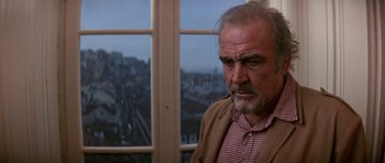 Movie still from “The Russia House” (1990), directed by Fred Schepisi – An older man standing in front of a large window; Close Up shot, Low angle