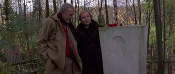 Movie still from “The Russia House” (1990), directed by Fred Schepisi – Two men standing next to a grave in a cemetery; Medium shot, Over the shoulder angle