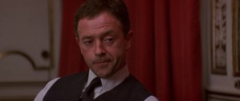 Movie still from “The Russia House” (1990), directed by Fred Schepisi – A person wearing a suit and tie; Close Up shot, Over the shoulder angle