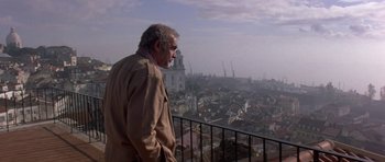 Movie still from “The Russia House” (1990), directed by Fred Schepisi – An older man standing on a balcony overlooking a city; Wide shot, Low angle