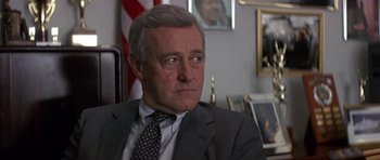 Movie still from “The Russia House” (1990), directed by Fred Schepisi – A person wearing a suit and tie; Close Up shot, Over the shoulder angle