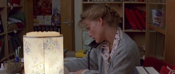 Movie still from “The Russia House” (1990), directed by Fred Schepisi – A woman sitting at a desk talking on the phone; Medium shot, High angle