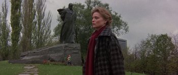 Movie still from “The Russia House” (1990), directed by Fred Schepisi – A woman standing in front of a statue in a park; Wide shot, Low angle