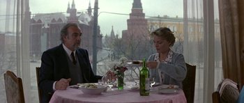 Movie still from “The Russia House” (1990), directed by Fred Schepisi – A man and a woman sitting at a table with a plate of food; Medium shot, Over the shoulder angle