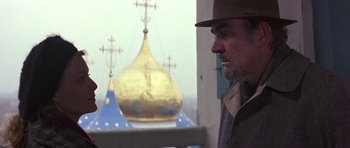 Movie still from “The Russia House” (1990), directed by Fred Schepisi – A man wearing a hat standing in front of a building; Close Up shot, Low angle