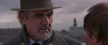 Movie still from “The Russia House” (1990), directed by Fred Schepisi – An older man wearing a hat and a coat; Close Up shot, Low angle