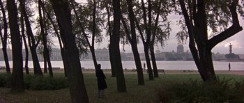 Movie still from “The Russia House” (1990), directed by Fred Schepisi – A person standing next to a body of water near trees; Extreme Wide shot, High angle