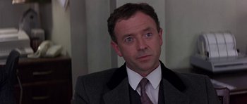 Movie still from “The Russia House” (1990), directed by Fred Schepisi – A person wearing a suit and tie; Close Up shot, Low angle