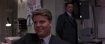 Movie still from “The Russia House” (1990), directed by Fred Schepisi – A man in a suit and tie standing in front of another man; Close Up shot, Over the shoulder angle