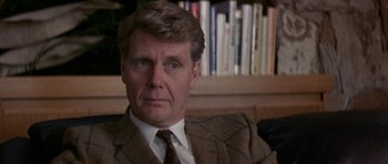 Movie still from “The Russia House” (1990), directed by Fred Schepisi – A person wearing a suit and tie; Close Up shot, Over the shoulder angle