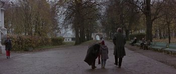 Movie still from “The Russia House” (1990), directed by Fred Schepisi – Two adults and a child walking down a path in a park; Wide shot, High angle