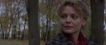 Movie still from “The Russia House” (1990), directed by Fred Schepisi – A person wearing a jacket near a tree; Close Up shot, Over the shoulder angle