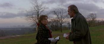 Movie still from “The Russia House” (1990), directed by Fred Schepisi – A man and a woman standing next to each other in a field; Medium shot, Over the shoulder angle
