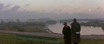 Movie still from “The Russia House” (1990), directed by Fred Schepisi – Two people standing on a bench looking out over a river; Extreme Wide shot, High angle