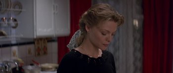 Movie still from “The Russia House” (1990), directed by Fred Schepisi – A woman in a black shirt with a white bow in her hair; Close Up shot, High angle
