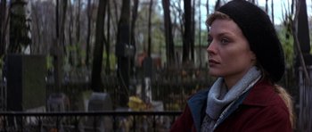 Movie still from “The Russia House” (1990), directed by Fred Schepisi – A woman standing in front of a grave yard; Close Up shot, Over the shoulder angle