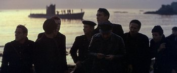 Movie still from “The Russians Are Coming the Russians Are Coming” (1966), directed by Norman Jewison – A group of men standing next to each other near a body of water; Wide shot, High angle