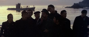 Movie still from “The Russians Are Coming the Russians Are Coming” (1966), directed by Norman Jewison – A group of men standing next to each other on a beach; Medium shot, High angle