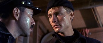 Movie still from “The Russians Are Coming the Russians Are Coming” (1966), directed by Norman Jewison – A man in a black hat and a man in a black jacket; Close Up shot, Over the shoulder angle