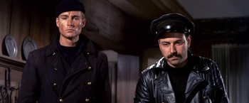 Movie still from “The Russians Are Coming the Russians Are Coming” (1966), directed by Norman Jewison – A man in a black leather jacket and a man in a black leather jacket; Medium shot, Low angle