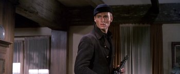 Movie still from “The Russians Are Coming the Russians Are Coming” (1966), directed by Norman Jewison – A man holding a gun while standing in a room; Close Up shot, Low angle