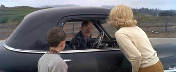 Movie still from “The Russians Are Coming the Russians Are Coming” (1966), directed by Norman Jewison – An older man sitting in a car with two young boys; Medium shot, Over the shoulder angle